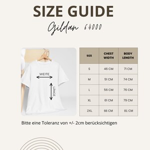 Peut inclure: Un t-shirt blanc sur un cintre, avec un guide des tailles. Le guide indique les tailles S &agrave; 2XL, la largeur de poitrine en cm et la longueur du corps en cm. Le texte "SIZE GUIDE" et "Gildan 64000" sont en haut.