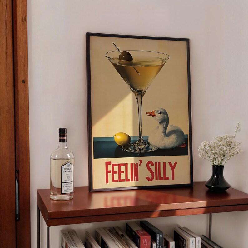 Puede incluir: Un p&oacute;ster vintage enmarcado con una copa de martini y un ganso. El p&oacute;ster tiene el texto "Feelin' Silly" en letras rojas.