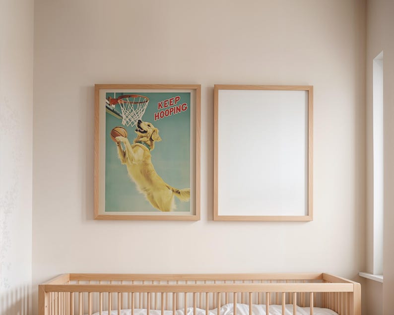 May include: Two framed prints hang above a wooden crib. One print features a golden retriever playing basketball with the text "KEEP HOOPING". The second frame is empty. The room has a neutral color palette.