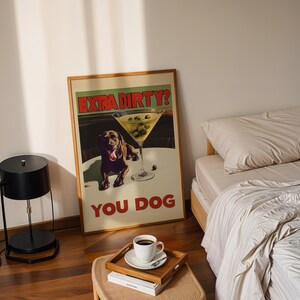 May include: A framed poster with a brown dog and a martini glass with olives. The poster has the text "Extra Dirty? You Dog" in red and black letters.