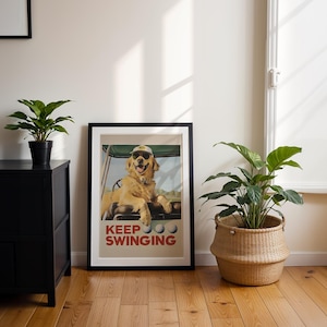 May include: A framed poster with a golden retriever wearing sunglasses and a golf cap. The dog is sitting in a golf cart. The poster has the text "KEEP SWINGING" in red and white letters.