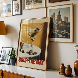 Peut inclure: Une affiche encadr&eacute;e avec une illustration vintage d'un verre &agrave; martini avec des olives et le texte "Soup of the Day".
