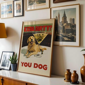 May include: A vintage poster with a golden retriever dog and a martini glass with olives. The poster has the text "Extra Dirty? You Dog" in red and white.