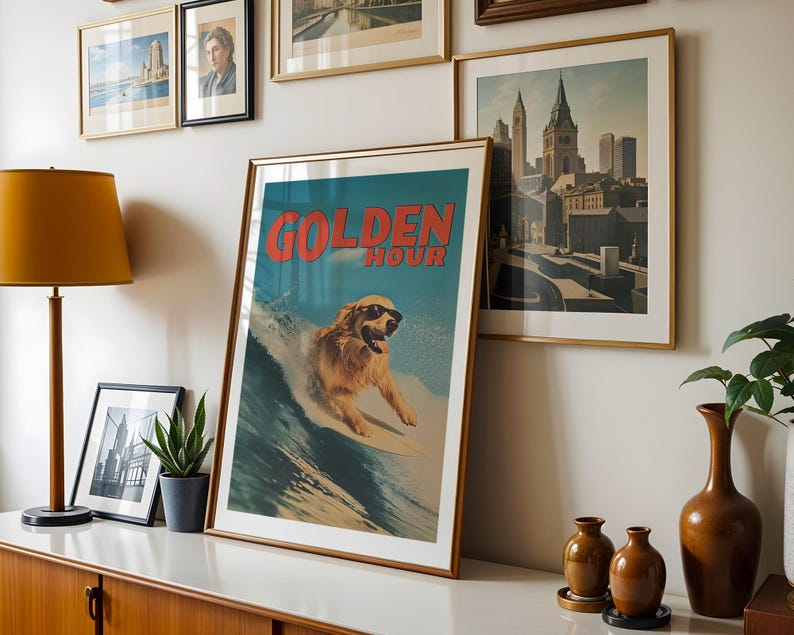 May include: A framed art print with a golden retriever surfing on a wave, wearing sunglasses. The print has the words "GOLDEN HOUR" in red. Other framed art pieces and a lamp are visible in the background.