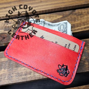 Cartera pequeña cosida a mano en color rojo con costuras azules de Pueblo