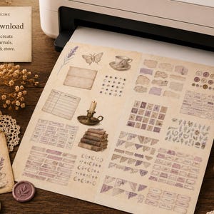 May include: A printer printing a sheet of vintage-style journal ephemera. The sheet includes illustrations of a teacup, butterfly, and candle, along with text that reads "Print at Home Instant Download". A lit candle and scissors are also visible.