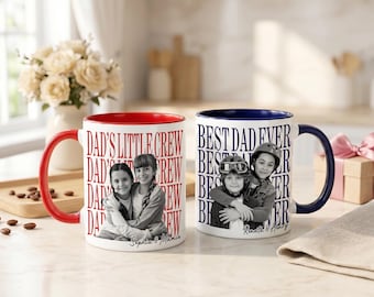 Könnte beinhalten: Zwei weiße Keramikbecher mit individuellen Fotos und Text. Ein Becher hat einen roten Innenraum und Henkel mit dem Text "DAD'S LITTLE CREW" und einem Foto von zwei Mädchen. Der andere Becher hat einen blauen Innenraum und Henkel mit dem Text "BEST DAD EVER" und einem Foto von zwei Kindern.