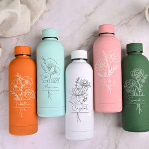 May include: Five colorful water bottles with floral designs and personalized names. The bottles are orange, light blue, white, pink, and green. Each bottle has a different flower design and name in a simple font.