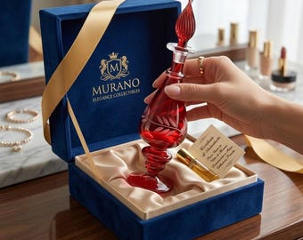 May include: A red Murano glass perfume bottle with a flame-shaped stopper, held in a blue velvet box with a gold ribbon. The bottle has etched floral designs. The box is labeled "Murano Elegance Collectibles."