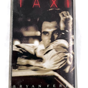 May include: A vintage cassette tape for the album "Taxi" by Bryan Ferry. The cover features a sepia-toned image of a man with the word "TAXI" in red letters at the top. The artist's name is printed at the bottom.