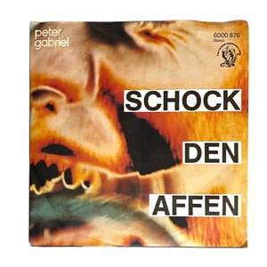 May include: Vintage Peter Gabriel album cover featuring an abstract, orange and brown face with the words "SCHOCK DEN AFFEN" in white block letters. The album cover also includes the text "peter gabriel" and a logo.