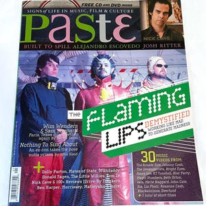 May include: A magazine cover with the word "Paste" in large letters. The cover features images of musicians and the text "The Flaming Lips." Additional text includes "Signs of Life in Music, Film & Culture."