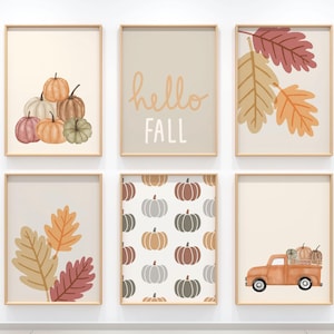 May include: Six framed art prints with a fall theme. The prints feature pumpkins, leaves, and a vintage truck. One print says "hello FALL". The colour palette includes orange, brown, and beige.