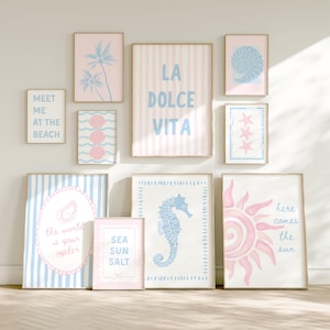 May include: A gallery wall set of ten framed prints featuring coastal themes in pastel pink and light blue. Designs include palm trees, seashells, a seahorse, a sun, and text reading LA DOLCE VITA, MEET ME AT THE BEACH, THE WORLD IS YOUR OYSTER, and SEA SUN SALT.