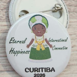 May include: White button with a cartoon illustration of a person in a green and yellow dress and headdress. The button has the words "Eternal Happiness International Convention" and "CURITIBA 2026" printed on it.