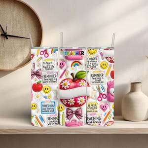 May include: A white tumbler with a straw, decorated with school-themed graphics. The design includes apples, rainbows, pencils, and the word "TEACHER". Inspirational quotes and smiley faces are also featured.