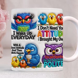 May include: White ceramic mug featuring colorful cartoon owls and text. The mug has various owl designs with phrases like "I Wake Up Everyday" and "I Don't Need Your Attitude." The mug is a fun, whimsical gift.
