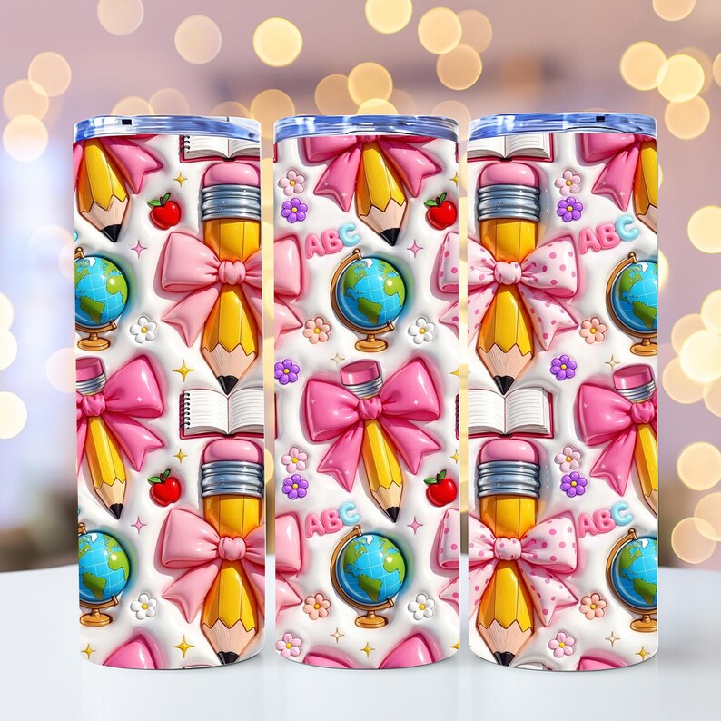 May include: Three white insulated tumblers with a repeating pattern of school-themed elements. The design includes yellow pencils with pink bows, globes, red apples, open books, and the letters "ABC".