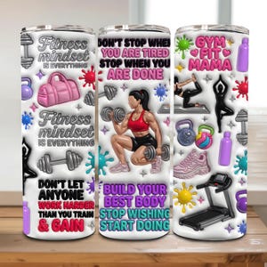 Op de afbeelding: Drie roestvrijstalen geïsoleerde bekers met fitness-thema ontwerpen. De ontwerpen bevatten motiverende tekst, dumbbells, yogahoudingen en een vrouw die gewichten heft. De bekers zijn versierd met roze, paarse en blauwe accenten.