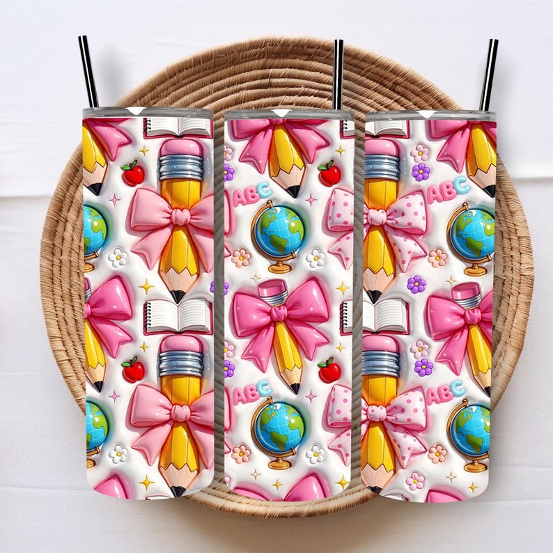 May include: Three stainless steel tumblers with a school-themed pattern. The design features yellow pencils with pink bows, globes, open books, red apples, and the letters "ABC" on a white background. Each tumbler has a black straw.