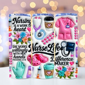 May include: A white tumbler featuring a nurse-themed design. The design includes a stethoscope, scrubs, shoes, and coffee cups. Text includes "Nursing is a work of heart", "Nurse Life", and "Difference Maker".