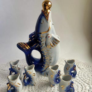 Può includere: Una tazza di ceramica bianca con manico nero e la scritta "But First, Coffee" in grassetto nero. La tazza è posta su uno sfondo neutro, che ne evidenzia il design semplice.