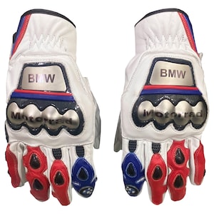 May include: A pair of white leather motorcycle gloves with the BMW logo and the word "Motorrad" in silver. The gloves have red, white, and blue accents and protective padding on the knuckles and fingers.