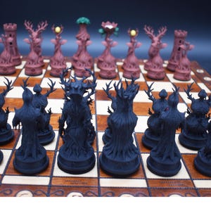 May include: A unique chess set with intricately designed pieces. The dark pieces are black tree-like figures, while the light pieces are brown with deer-like antlers and floral accents. The set is displayed on a wooden chessboard.