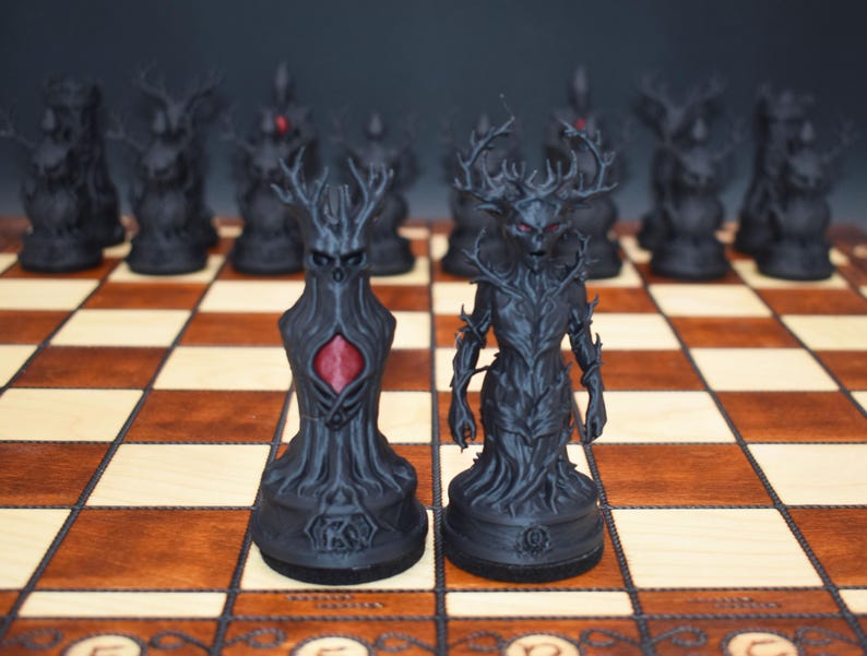 May include: A black chess set with intricately designed pieces. The pieces feature a dark, gothic aesthetic with antler-like structures and red accents. The chess board is made of wood with a checkered pattern.