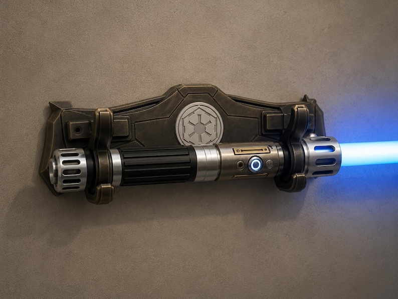 K&ouml;nnte beinhalten: Eine bronzefarbene Lichtschwert-Wandhalterung mit einem silbernen und schwarzen Lichtschwert. Das Lichtschwert strahlt einen hellblauen Strahl aus. Die Wandhalterung hat ein Symbol in der Mitte.
