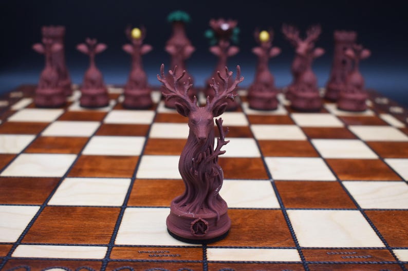 May include: A burgundy chess set with a deer-shaped king piece. The chess pieces are arranged on a wooden chessboard with light and dark squares. Other pieces include a tower, a bishop, and a queen.