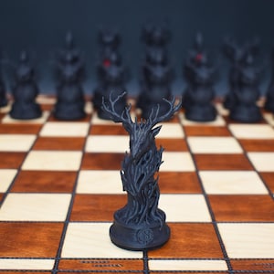 May include: A black chess set with a unique design. The chess pieces are arranged on a wooden chessboard. The focal point is a stag chess piece, with other pieces in the background. The board has alternating light and dark squares.