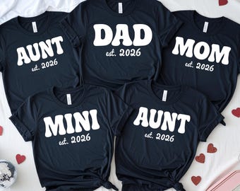 Magliette personalizzate abbinate per la famiglia per annunciare la gravidanza di papà, mamma e mini-bambino (prevista per il 2026).