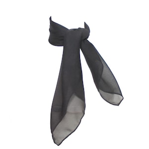 May include: A black sheer scarf tied in a knot. The scarf is made of a lightweight fabric and has a soft, flowing drape.