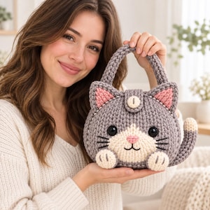 Peut inclure: Un sac à main en crochet gris en forme de chat avec un museau crème, des oreilles intérieures roses et un nez rose. Le sac présente des moustaches brodées noires, deux yeux ronds noirs, une petite queue sur le côté et une anse à bouton.