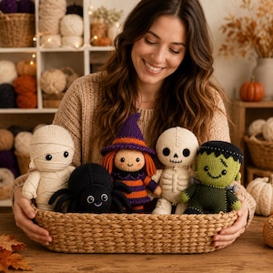Puede incluir: Una cesta tejida que contiene cinco muñecos de ganchillo de Halloween: una momia color crema, una araña negra, una bruja con sombrero morado y pelo naranja, un esqueleto blanco y un monstruo de Frankenstein verde.