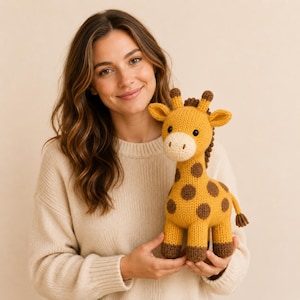 May include: A knitted giraffe soft toy featuring a golden yellow body with dark brown circular spots, a cream-coloured muzzle, two small horns, and dark brown hooves. The toy has black button eyes and a dark brown mane running down its neck.