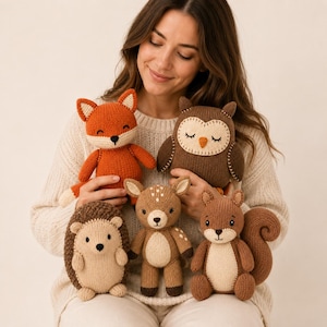 May include: A collection of five knitted stuffed animals including a bright orange fox, a dark brown owl with a cream face, a light brown hedgehog, a tan fawn with white spots, and a brown squirrel with a large curled tail, all made of yarn.