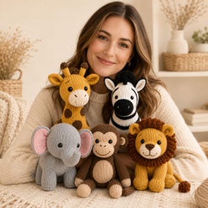 May include: A collection of five knitted stuffed animals including a yellow giraffe with brown spots, a black and white zebra, a grey elephant with pink ears, a brown monkey with a tan belly, and a yellow lion with a brown mane.