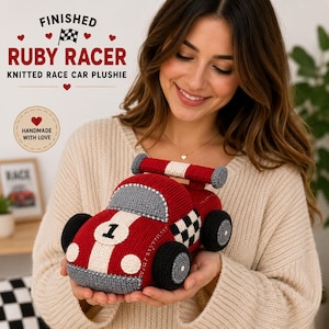 Puede incluir: Un coche de carreras de peluche tejido en rojo con una franja blanca, el número uno en negro y un patrón de cuadros en el lateral. El coche cuenta con un alerón trasero, parachoques grises y ruedas negras. Texto: FINISHED RUBY RACER KNITTED RACE CAR PLUSHIE.