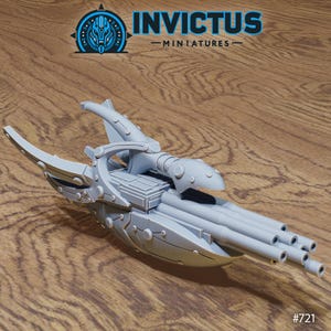 Puede incluir: Maqueta de nave espacial en miniatura de color gris claro con múltiples cañones y un diseño detallado. El modelo tiene el texto "INVICTUS -MINIATURES-" y el número "#721".