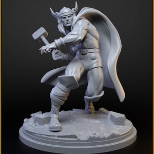 Może przedstawiać: Szara figurka Thora, trzymającego młot, z peleryną i hełmem. Figurka stoi na podstawie z napisem "CLASSIC THOR" i "40mm on 35mm base". Podstawa ma wzór pękniętego kamienia. Wydanie z lutego Patreon.