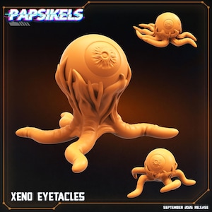 May include: Orange-colored Xeno Eyetacles sculpture. The sculpture features a large eye with tentacles and two smaller versions. The text "Papsikels" and "Xeno Eyetacles" are visible. The release date is September 2025.