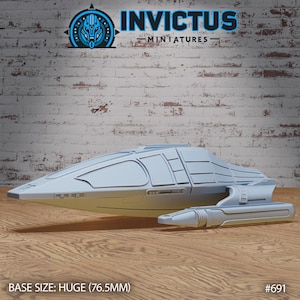 May include: A light gray spaceship model with a sleek design, featuring a cockpit and detailed panels. The model is labeled "INVCTUS MINIATURES" and has a base size of 76.5mm. The background is a brick wall and wooden surface.