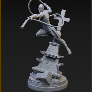 Może przedstawiać: Szara figurka Silver Age Daredevil w dynamicznej pozie, dzierżąca broń. Figurka stoi na szczegółowej podstawie z krzyżem i elementami architektonicznymi. Podstawa ma 40 mm na podstawie 35 mm. Widoczny jest tekst "SILVER AGE DAREDEVIL (YELLOW SUIT)".