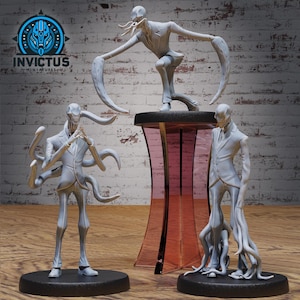 Puede incluir: Tres figuras grises en miniatura de criaturas humanoides con trajes. Una figura está arrodillada sobre una plataforma negra, otra está de pie sobre una plataforma negra y la tercera está sobre un pedestal transparente teñido de rosa. El logotipo de Invictus Miniatures está en la esquina superior izquierda.