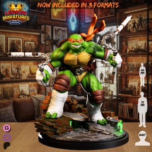 Op de afbeelding: Een groene en gele Teenage Mutant Ninja Turtle-figuur met oranje hoofddeksel en een bruine riem, die wapens vasthoudt. De basis is een bakstenen en metalen ontwerp. De tekst "NOW INCLUDED IN 3 FORMATS" staat bovenaan. De figuur is ongeveer 7,5 cm hoog.