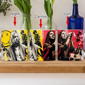 May include: A white ceramic mug featuring a split-design graphic print. The left side displays a yellow background with a black smiley face logo and a portrait of a musician. The right side features a red background with a portrait of a singer.