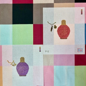 May include: Two needlepoint canvases featuring perfume bottle designs. One bottle is red with a gold top, the other is purple with a gold top. Both have a small floral design and the initials "NW".