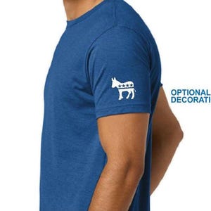 Puede incluir: Camiseta azul de manga corta con un dise&ntilde;o de burro blanco y estrellas en la manga izquierda. El texto "OPTIONAL DECORATION" est&aacute; a la derecha de la camiseta. La camiseta est&aacute; hecha de una tela suave y texturizada.